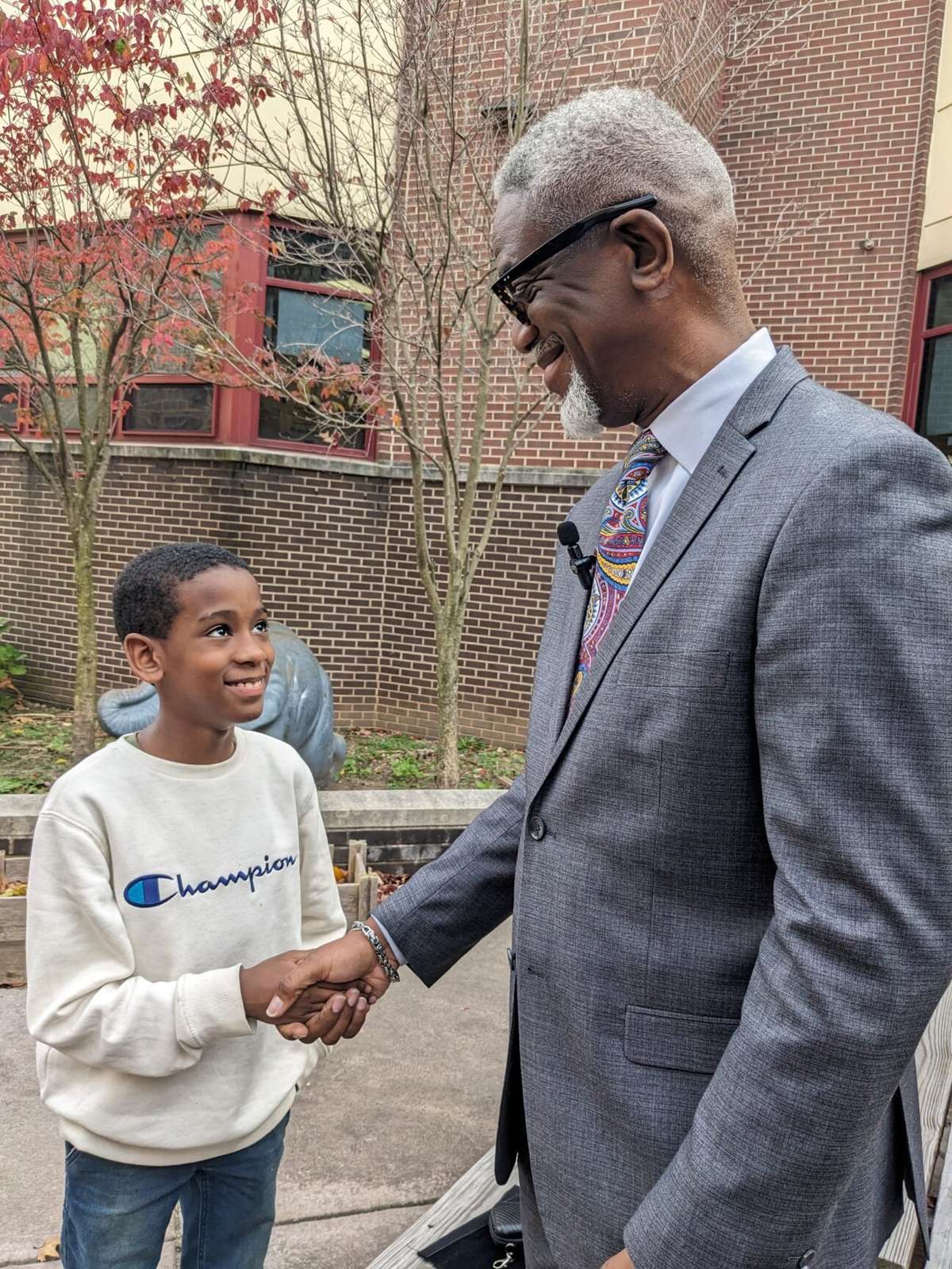 Dr. Eric J. Becoats greeting a student outside a school